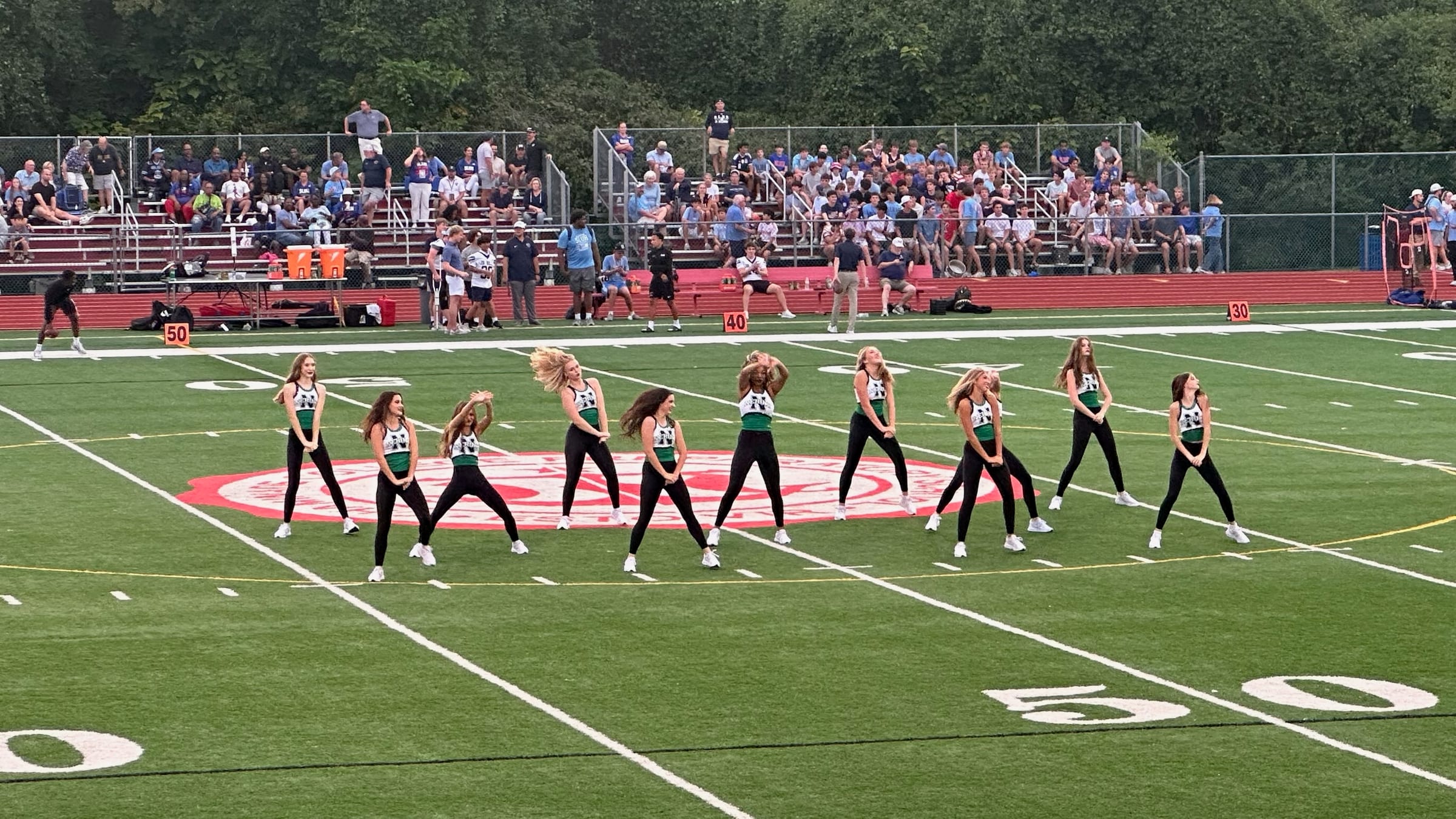 New school, new team, first routine. The whole family in the bleachers, grandparents included.